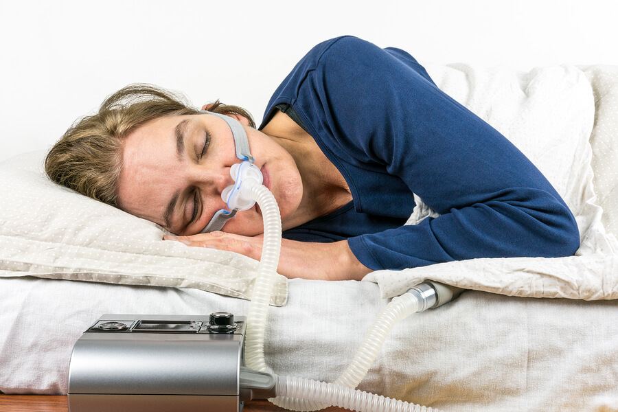 Woman sleeping with Sleep Apnea machine